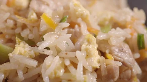 Macro view of steaming chicken fried rice with eggs and vegetables rotating.. Vídeos de archivo 332578985