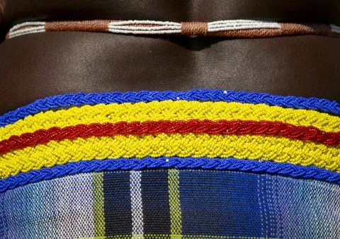 Macro view of a striped beaded belt in blue yellow and red resting above a .. Foto stock