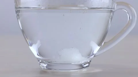 Macro View of Sugar Cube Dissolving in Glass Cup of Water 스톡 동영상 341854110