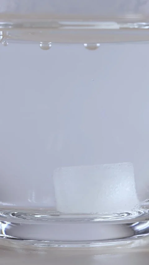 Macro View of Sugar Cube Dissolving in Clear Water Glass Stock Footage 342488565