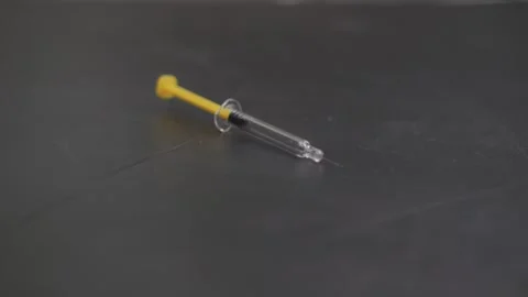 Macro view of syringes falling onto a black surface, with fine needles and .. Stock Footage 303573190