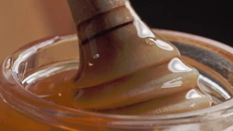 Macro View of Thick Amber Syrup Being Stirred in Glass Container in Mexico Stock Footage 345101232