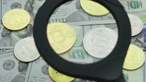 Macro view through a magnifying glass on a bitcoin coins on a table with dollars 스톡 동영상 209519771