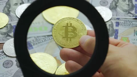Macro view through magnifying glass on gold bitcoin coins on table with dollars 스톡 동영상 216668822