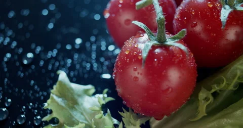 Macro view of tomatoes and salad leaves on dark background, for ads and packshot Stock Footage 134458040