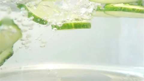 Macro View of Water with Sliced Cucumber Pieces with Bubbles in Slow Motion Stock Footage 129261144