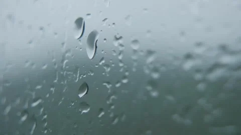 Macro view of wet window with scattered droplets shining under natural light and Stock Footage 323438940