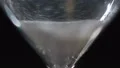 Macro view of white sand going down in hourglass on the table, measuring device HD Footage