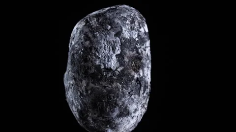 Macro view of a whole potato baked in coals on black background, rotates Vidéo 334652331