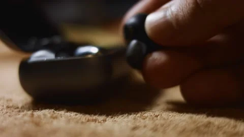 Macro view of wireless earphones in the charging case. Male's hand taking an Stock Footage 144938069
