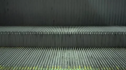 A macro view of a yellow and grey escalator stairs sliding steadily upwards Stock Footage 59762866
