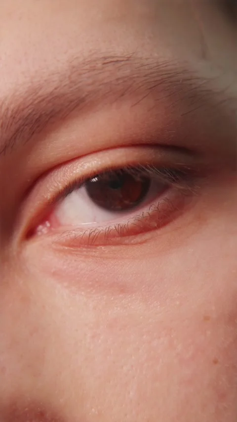 Macro view of young man brown eye looking forward Stock Footage 347068952