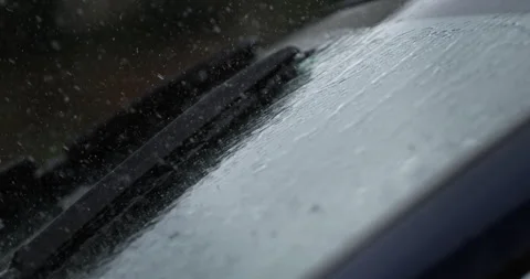 Macro of water drops cleaned with car wipers from windshield glass while rains Stock Footage 268981490