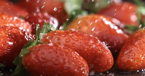 Macro of water drops falling on fresh red strawberries while raining at farm Stock Footage 268802318