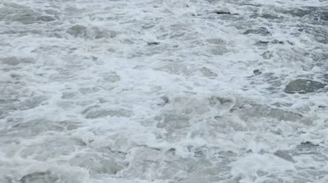 Macro waves in the dark sea breaking on the shore with the formation of spray Stock Footage 62890580