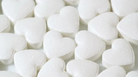 Macro white heart shape drugs, closeup medical pills rotating, medicine concept 스톡 동영상 197246239