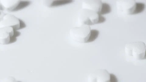 Macro white heart shape drugs, closeup medical pills falling, medicine concept Stock Footage 235507807