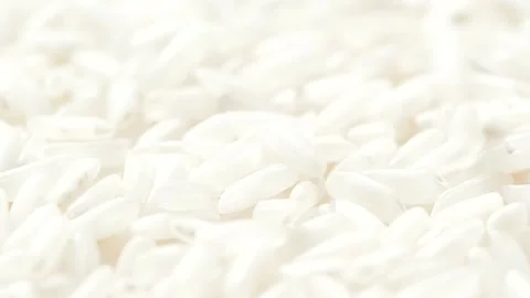 Macro white raw rice grain falling down, food background, slow motion video Stockbeeldmateriaal 143301476