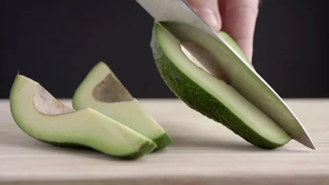Macro wide close up of knife slicing and chopping a green avocado Stock Footage 273511309