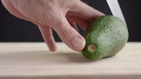 Macro wide close up of knife slicing and chopping a green avocado Stock Footage 273511492