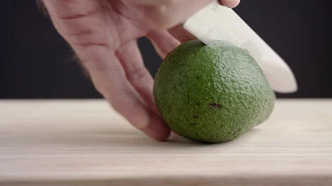 Macro wide close up of knife slicing and chopping a green avocado Stock Footage 273511506