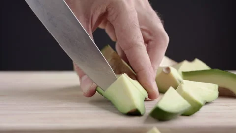 Macro wide close up of knife slicing and chopping a green avocado Stock Footage 273511752