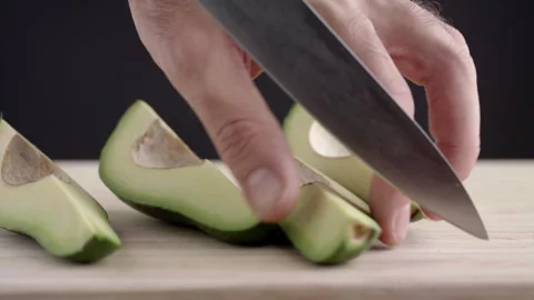 Macro wide close up of knife slicing and chopping a green avocado Stock Footage 273511811