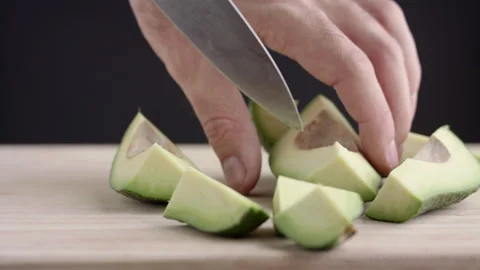 Macro wide close up of knife slicing and chopping a green avocado Stock Footage 273511818