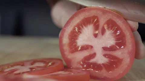 Macro wide close up of knife slicing and chopping a red tomato salad, food, Stock Footage 273512433