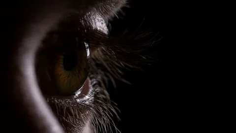 Macro of young man eye opening and blinking in the dark Vídeos de archivo 75540324