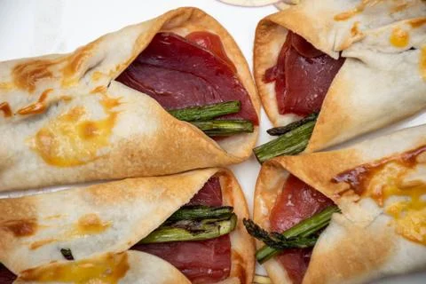 Macro zenithal view of some covers. Salted ham canap with wild asparagus wrap Stock Photos