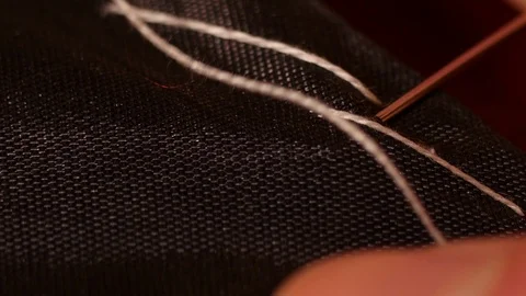 Macroscopic shot of man tailor hand sewing black line with white basting thread. Video stock 126499605