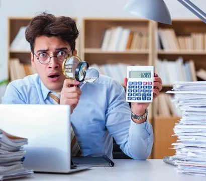 The mad auditor looking for errors in the report 스톡 사진