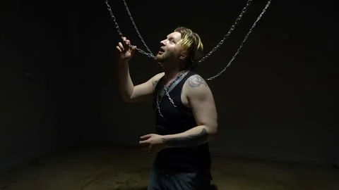 Mad blond man bound in chains Stock Footage 95735838