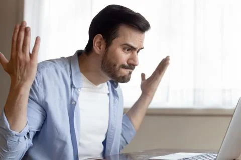 Mad Caucasian man having computer problems working on laptop Stock Photos