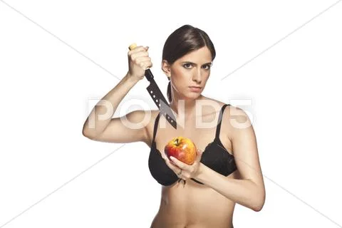 Mad girl stabbing apple Stock Photos
