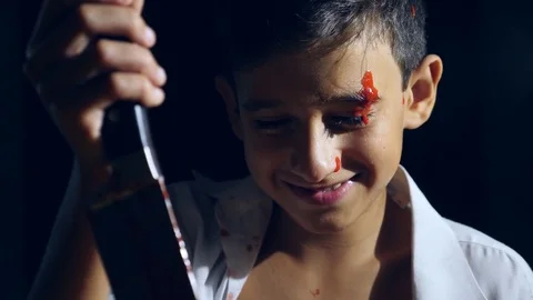 A mad man, a demon that has become a child, a gripping knife, covered in blood Stock Footage 79734597