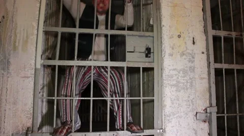 Mad prisioner stands on a cell door. Criminal dance on a prison door. Funny Stock Footage
