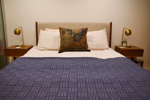Made bed in between two night tables Stock Photos