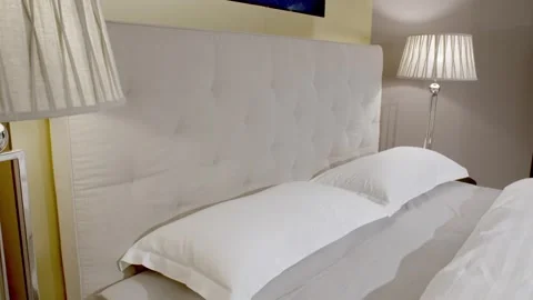 Made Bed with Upholstered Headboard and Bedside Lamp, Cozy Bedroom, Warm Light Видео 341396181