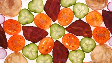 Made dish with sliced assorted meat and vegetables rotating on white in 4K. Vídeo Stock 87069753