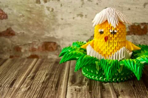 Made of paper by a yellow Easter cute chicken in a paper grass basket Stock Photos