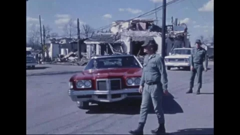 MADISON - 1974: Tornado Aftermath — Field jacket at curb, then car waved through Stock Footage 342230341