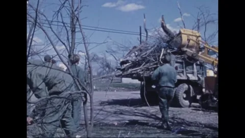 MADISON - 1974: Tornado Aftermath — Loader tips brush into heaped truck Stock Footage 342230271