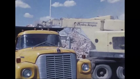 MADISON - 1974: Tornado Aftermath — Tracked excavator loads yellow dump truck Stock Footage 342230178