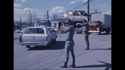 MADISON - 1974: Tornado Aftermath — Two soldiers signal red box truck through Stock Footage 342230355