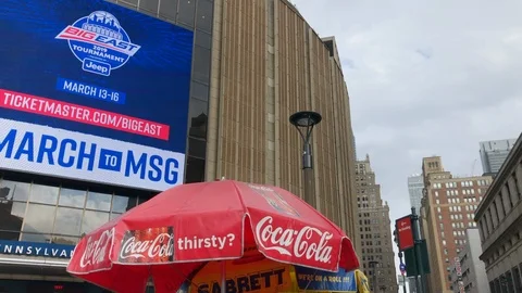 Madison Square Garden.
Pan outside gate B 
Coca Cola umbrella on food Video stock 104831264