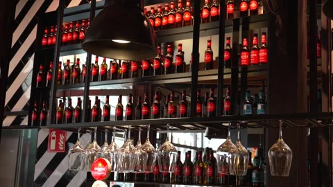 Madrid Spain bar interior with multiple Estrella Damm beer bottles on shelves Stock Footage 336757535