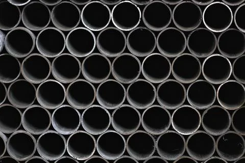 Maetallic pipes of the same diameter are neatly stacked. View of pipes from the Stock Photos