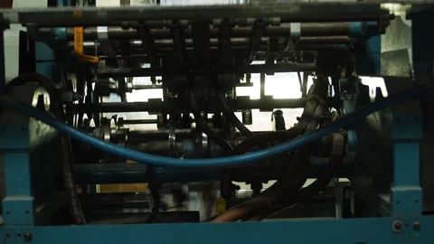 Magazines drop down onto a conveyor belt at a printing press Stock Footage 130144393
